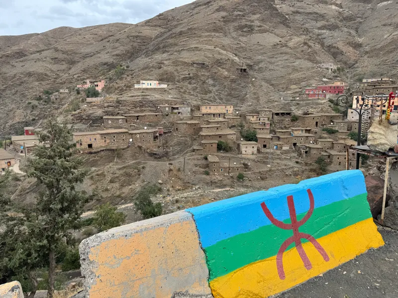 Amazigh flag painted on a wall overlooking a traditional village in the Atlas Mountains