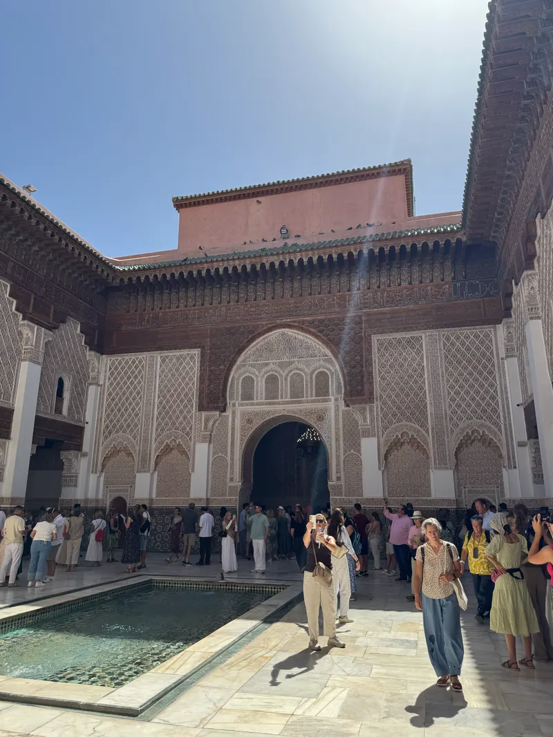 Madrassa Ben Youssef courtyard crowded with visitors at midday